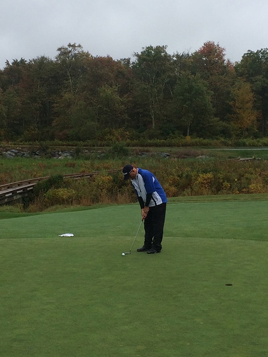 Brian D. lining up his putt on the Par-3 8th.