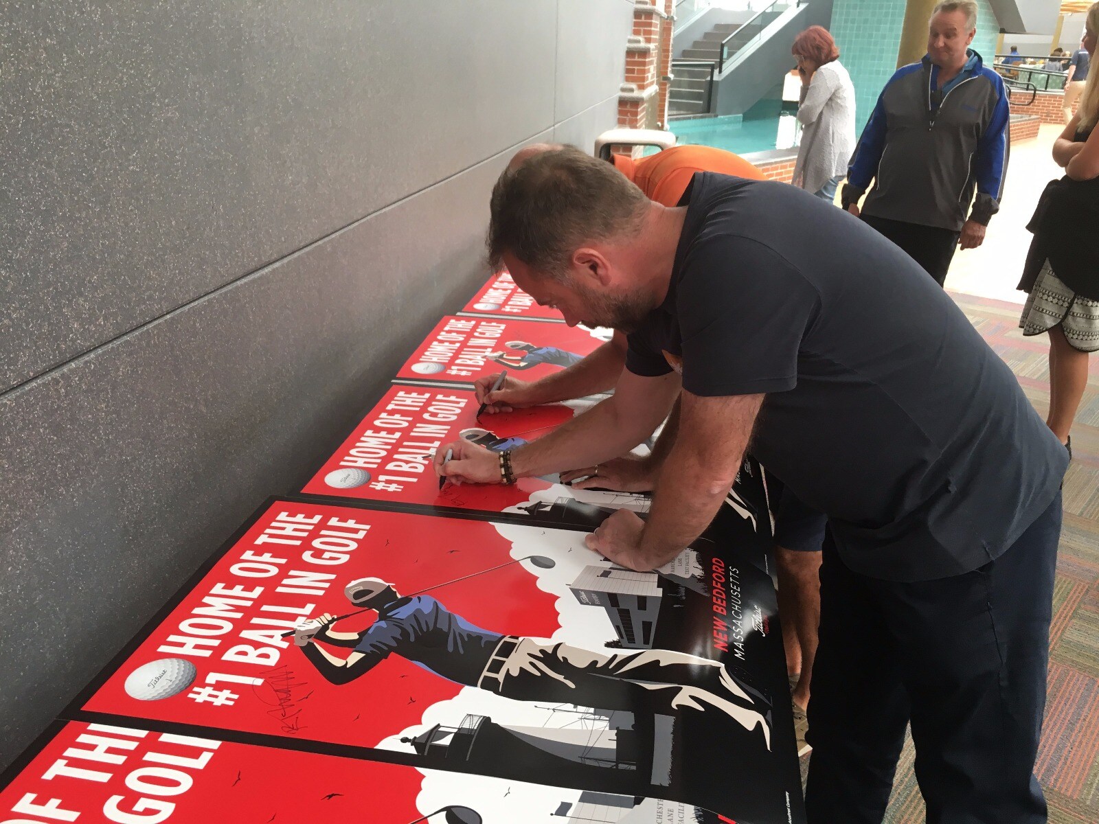 Signing promotional posters.